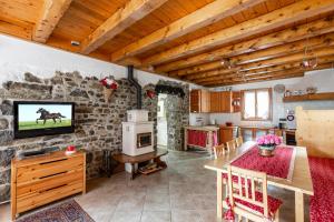 a living room with a table and a kitchen with a stone wall at Lioda Hiking in Venas