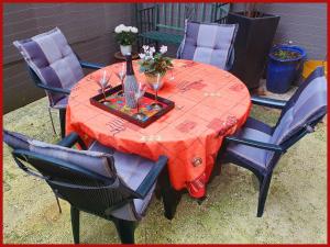 een rode tafel met stoelen en een vaas met bloemen erop bij Chambre privée avec petit déjeuner dans maison de ville - Saint mandé- Paris in Saint-Mandé