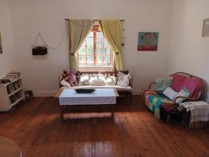 un soggiorno con un divano e un tavolo di Karoo Cottage Comfort in Uniondale a Uniondale