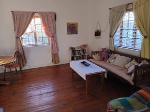 un soggiorno con un divano e un tavolo di Karoo Cottage Comfort in Uniondale a Uniondale