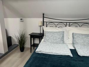 um quarto com uma cama em preto e branco e uma mesa em Bükkös Apartman em Szentendre