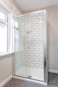 a shower with a glass door in a bathroom at Castlereagh guest House in Belfast
