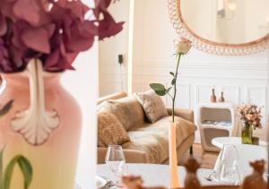 una sala de estar con sofá y un jarrón de flores en Rare! Magnifique appartement - Vue Cathédrale en Reims