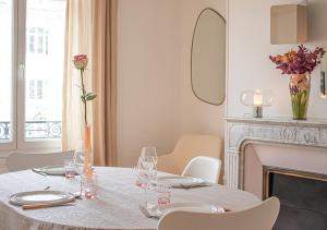 uma sala de jantar com uma mesa com copos e uma lareira em Rare! Magnifique appartement - Vue Cathédrale em Reims