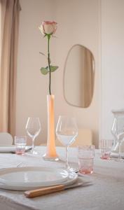 a rose in a vase on a table with glasses at Rare! Magnifique appartement - Vue Cathédrale in Reims