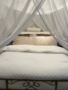 two beds with white sheets and a canopy at Bachelorette Suite in Washington, D.C.