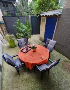 een rode tafel en stoelen in een tuin bij Chambre privée avec petit déjeuner dans maison de ville - Saint mandé- Paris in Saint-Mandé