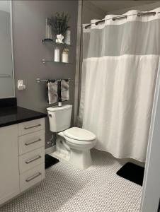 a bathroom with a toilet and a shower curtain at Bachelorette Suite in Washington