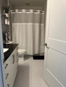 a bathroom with a white shower curtain and a toilet at Bachelorette Suite in Washington, D.C.