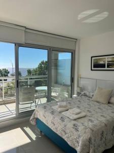 a bedroom with a large bed and a balcony at Solares de Araus, Monoambiente in Colonia del Sacramento