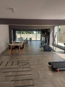 ein Wohnzimmer mit einem Fitnessraum mit einem Tisch und Fitnessgeräten in der Unterkunft Solares de Araus, Monoambiente in Colonia del Sacramento