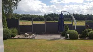 een patio met een parasol in een tuin bij Haus Nordsee in Emden