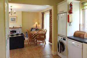 a kitchen and living room with a table and chairs at Leitrim Quay - Riverside Cottage 9 in Leitrim