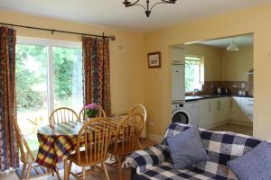 a kitchen and dining room with a table and chairs at Leitrim Quay - Riverside Cottage 9 in Leitrim