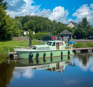 a boat is docked at a dock in the water at Leitrim Quay - Riverside Cottage 9 in Leitrim
