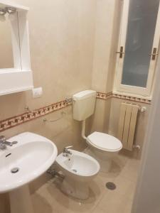 uma casa de banho com um WC branco e um lavatório. em La Vela Apulia Seaside Residence em Margherita di Savoia