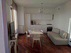 cocina y sala de estar con mesa y sofá en Il Molino Apartment, en Pescara