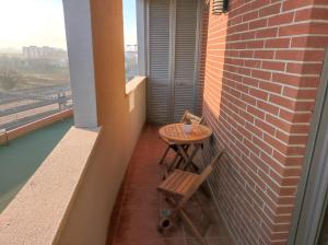 - Balcón con mesa pequeña y 2 sillas en Il Molino Apartment, en Pescara