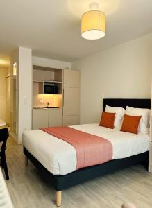a bedroom with a large bed with orange pillows at Twenty Business Flats Lille - Bayard in Lille