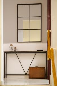 a mirror on a wall above a table at ALBERGO DIFFUSO ROSSI DIMORA Di CHARME in Turi