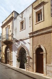 an old building with two arched doors on a street at ALBERGO DIFFUSO Dimora Rossi Charme in Turi