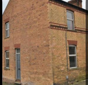 a brick building with three windows on the side of it at Stamford - 2 bed terrace house in Lincolnshire