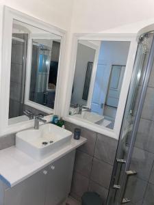a bathroom with two sinks and mirrors and a shower at Sage Home - sweet & snuggly in Denton