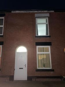 a brick building with a white door and a window at Sage Home - sweet & snuggly in Denton