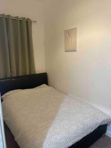 a bed in a bedroom with a picture on the wall at Sage Home - sweet & snuggly in Denton