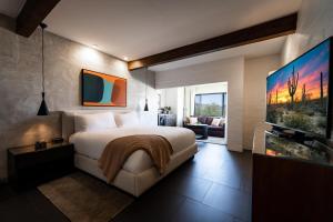 a bedroom with a large bed and a flat screen tv at Sanctuary Camelback Mountain, A Gurney's Resort and Spa in Scottsdale