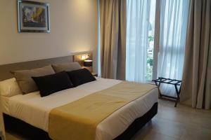 Un dormitorio con una cama grande con una ventana grande. en Amérian Río Cuarto, en Río Cuarto