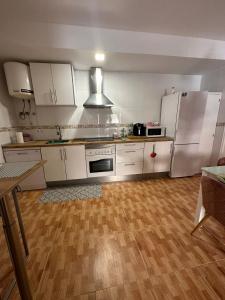a kitchen with white appliances and a wooden floor at Apartamento Brisa junto al mar in Roquetas de Mar