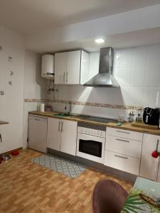 a kitchen with white cabinets and a stove top oven at Apartamento Brisa junto al mar in Roquetas de Mar