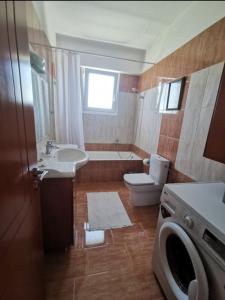 a bathroom with a toilet sink and a washing machine at Up on the hill in Nafpaktos