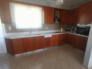 a kitchen with brown cabinets and a window and a sink at Up on the hill in Nafpaktos