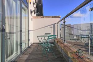 a balcony with tables and chairs on a building at Stylish 3Bedrooms 2 Bath in Harold wood Romford in Harold Wood