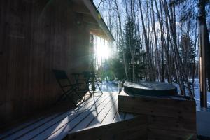 a porch of a cabin with the sun shining through the trees at Paunküla Nature Resort (forest villa) in Ardu