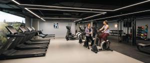 a man and woman standing on exercise bikes in a gym at Luxury Apartment Cherrywood Dublin 18 in Dublin