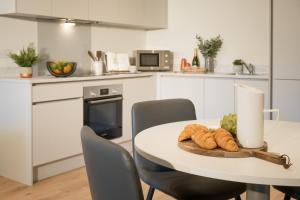 eine weiße Küche mit einem Tisch mit einem Teller Brot in der Unterkunft Luxury Apartment Cherrywood Dublin 18 in Dublin