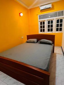 a bedroom with a bed in a yellow room at SRI RAGAVAS LAGOON VILLA in Katunayaka