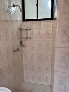 a bathroom with a shower with white tile at Amplio y cómodo departamento in Cochabamba