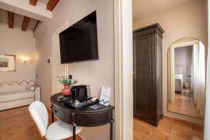 um quarto com uma mesa e uma televisão na parede em Daplace - Antica Casa Coppo em Veneza