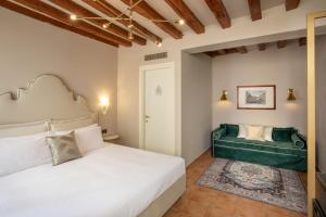 um quarto com uma cama e um sofá verde em Daplace - Antica Casa Coppo em Veneza