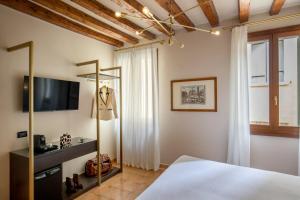 um quarto com uma cama e uma televisão de ecrã plano em Daplace - Antica Casa Coppo em Veneza