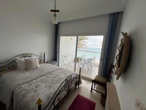 a bedroom with a bed and a view of the ocean at Mahdia vue sur mer 2 in Hiboun