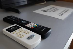 two remote controls sitting on top of a desk at Special Apartment in Larisa
