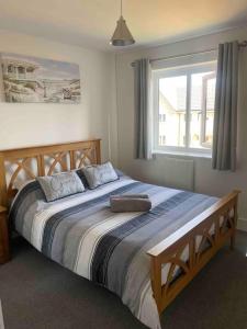 a large bed in a bedroom with a large window at Modern home on the edge of the Cotswolds in Evesham