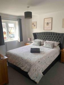 a bedroom with a large bed with a large headboard at Modern home on the edge of the Cotswolds in Evesham