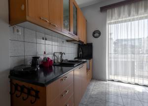 a kitchen with wooden cabinets and a black counter top at Special Apartment in Larisa