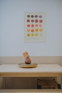 une table avec une plaque et un vase sur elle dans l'établissement L'Assas, à Dijon